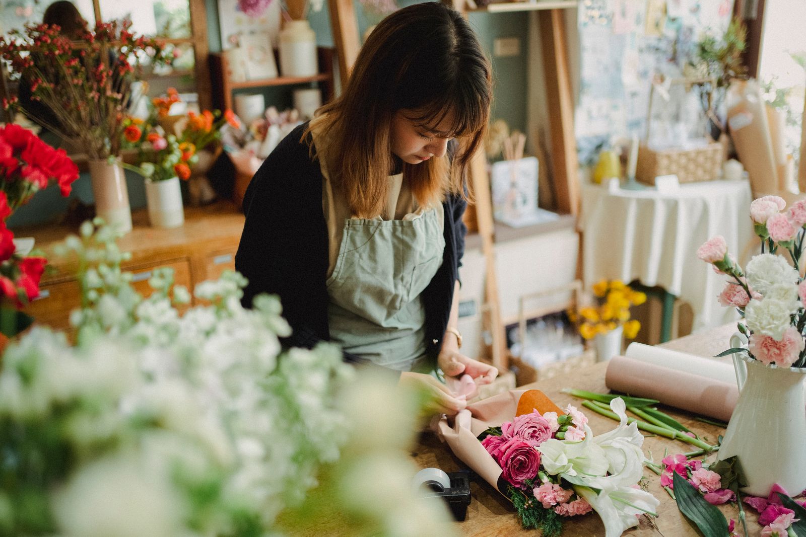 A florist concentrating on a bouquet in a flower shop.